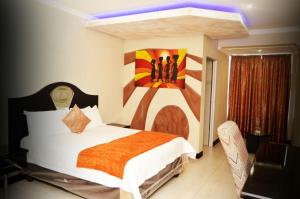 Schlafzimmer mit einem Bett mit Wandgemälde in der Unterkunft Kismet Hotel in Pietermaritzburg