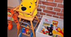 a stuffed winnie the pooh sitting in a high chair at Hostel Suomenlinna in Helsinki