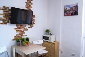 ズヴェニゴロドにあるSuponevo Studio Apartment Zvenigorodのリビングルーム(テーブル、壁掛けテレビ付)