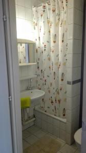 a bathroom with a sink and a shower curtain at West City Apartments in Budapest