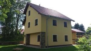 żółty dom z dachem w obiekcie Horní Planá w mieście Horní Planá