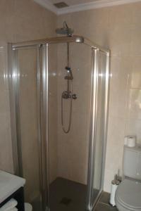a shower stall in a bathroom with a toilet at Guest House Sabores da Beira in Castro Marim