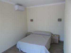 a bedroom with a white bed in a room at Guest House Sabores da Beira in Castro Marim