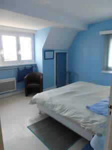 een blauwe slaapkamer met een bed en een stoel bij Maison de villégiature cote opale in Hardelot-Plage