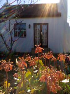 a house with a flower garden in front of it at Orchard Cottage in McGregor