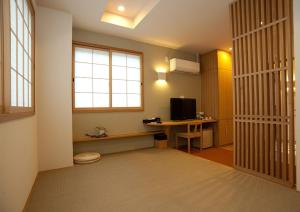 Habitación con escritorio, ordenador y ventana. en Mizuhasou, en Miyajima
