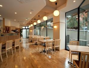 a restaurant with wooden tables and chairs and windows at Mizuhasou in Miyajima