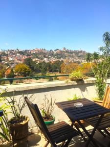 a table and chairs on a balcony with a view at TANA-JACARANDA in Antananarivo