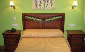 a bedroom with a large wooden bed and two night stands at San Miguel de la Barreda in Siero