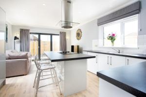 a kitchen with white cabinets and a black counter top at Northwood 2 in Broadstairs