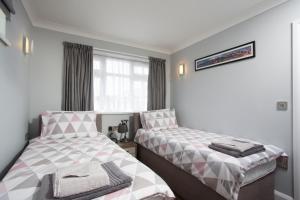 um quarto com 2 camas e uma janela em Northwood 2 em Broadstairs