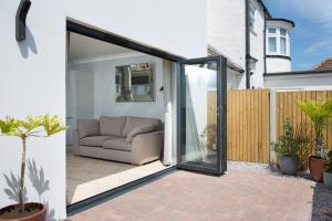 a sliding glass door opens onto a patio with a couch at Northwood 2 in Broadstairs