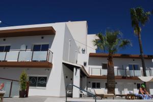 a white building with palm trees in front of it at Hotel Moli Boutique in Alfaz del Pi