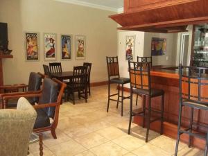 a bar with chairs and a table in a restaurant at Lavender Lodge in Vryburg