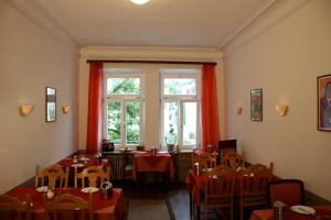 a dining room with tables and chairs and a window at Hotel Pension Schmellergarten in Munich