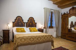 una camera da letto con un grande letto con cuscini gialli di Casa Go'El a Chiaramonte Gulfi