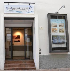 un negozio con un cartello sul lato di un edificio di RivAppartamenti a Riva del Garda