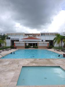 a large swimming pool in front of a building at Beach Front Apartment Rio Mar Puerto Rico in Rio Grande