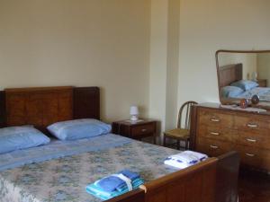 a bedroom with a bed and a dresser and a mirror at Villa Spaia in Brancaleone Marina