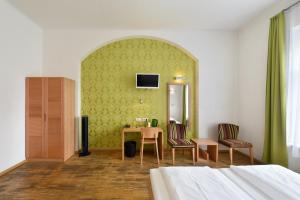 a bedroom with a table and two chairs and a mirror at Hotel Mocca in Vienna