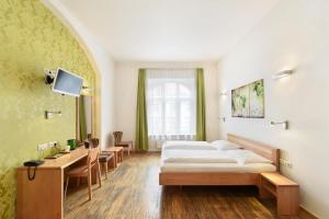 a bedroom with a bed, desk, chair, and lamp at Hotel Mocca in Vienna