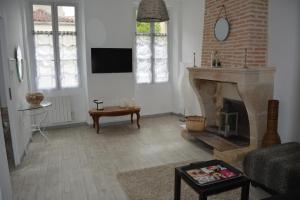 un salon avec une cheminée et une télévision dans l'établissement Arc en ciel, à Lesparre-Médoc