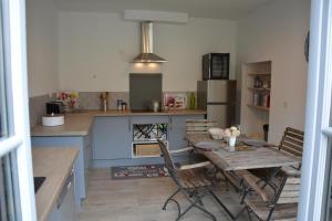 een keuken met een tafel en stoelen in een kamer bij Arc en ciel in Lesparre-Médoc