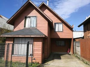 a pink house with two windows and a fence at Cabaña Villarrica 1254 in Villarrica