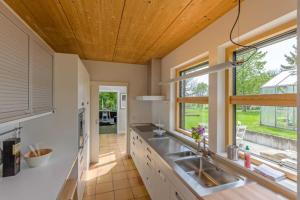 cocina con encimeras blancas y techo de madera en Feriendomizil M No_ 7_1, en Villingen-Schwenningen