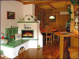 a living room with a fireplace and a dining room with a table at Gasthaus & Pension Zum Hirsch in Gehlberg