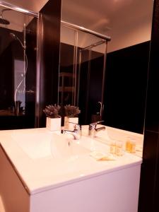 bagno con lavandino bianco e specchio di Innapartments São Gonçalinho II ad Aveiro