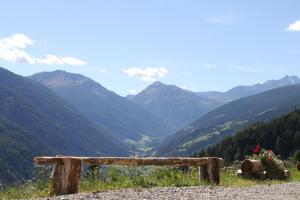 un banco sentado en la cima de una colina con vistas a un valle en Mitterhof, en Ultimo