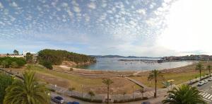 a view of a river with cars parked on a street at Hostal Brisa do mar in Portonovo