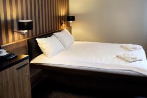 um quarto com uma cama com duas toalhas em Amadeus em Lomza