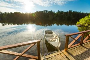 Ein Boot liegt an einem Dock auf einem See. in der Unterkunft Holiday Park Lesnaya Skazka in Wyborg