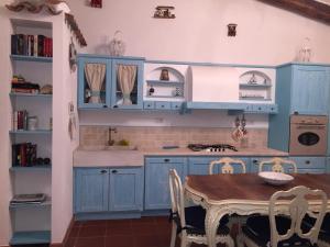 cocina con armarios azules y mesa en Villaggio la Marmorata, en Santa Teresa Gallura