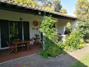 a patio of a house with a wooden table at Villetta nella Pineta Santa Margherita di Pula in Santa Margherita di Pula