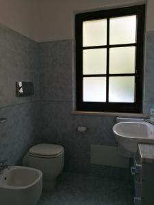 a bathroom with a toilet and a sink and a window at Villetta nella Pineta Santa Margherita di Pula in Santa Margherita di Pula +25 photos