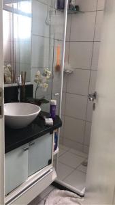 La salle de bains est pourvue d'un lavabo et d'une douche. dans l'établissement Apartamento 2 Quartos vista mar, à Salvador