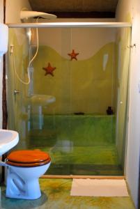 a bathroom with a toilet and a shower with stars on the wall at Pousada Shangri-lá in Itacaré
