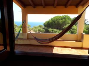 a hammock in a room with a view of the ocean at Casa Nicoletta in Ustica