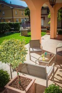 un patio con 2 sillas, una mesa y un árbol en Appartamenti vicino al mare, en Civitanova Marche