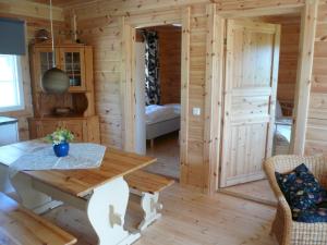 een houten hut met een tafel en een slaapkamer bij Cottage Kivitatti in Sysmä