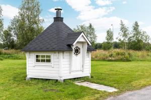 a small white house with a black roof at Apartment Kievarinhovi in Kempele