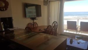 comedor con mesa y ventana grande en Departamento Resort Lagunas del Mar, en La Serena