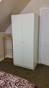 a white cabinet in a room with a bed at Central Dumfries in Dumfries