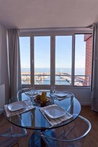 una mesa de comedor de cristal con vistas a la ciudad en Candela's Beach Port, en Masnou