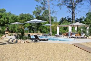 een zwembad met stoelen en parasols naast bij Villa CARPE DIEM in Lorgues