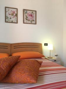 サリーチェ・テルメにあるBilocale Salice Termeのベッドルーム1室(ベッド1台付)が備わります。壁に2枚の写真が飾られています。