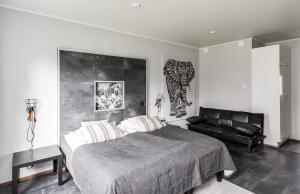 a bedroom with a bed and a leather couch at Apartment Kievarinhovi in Kempele